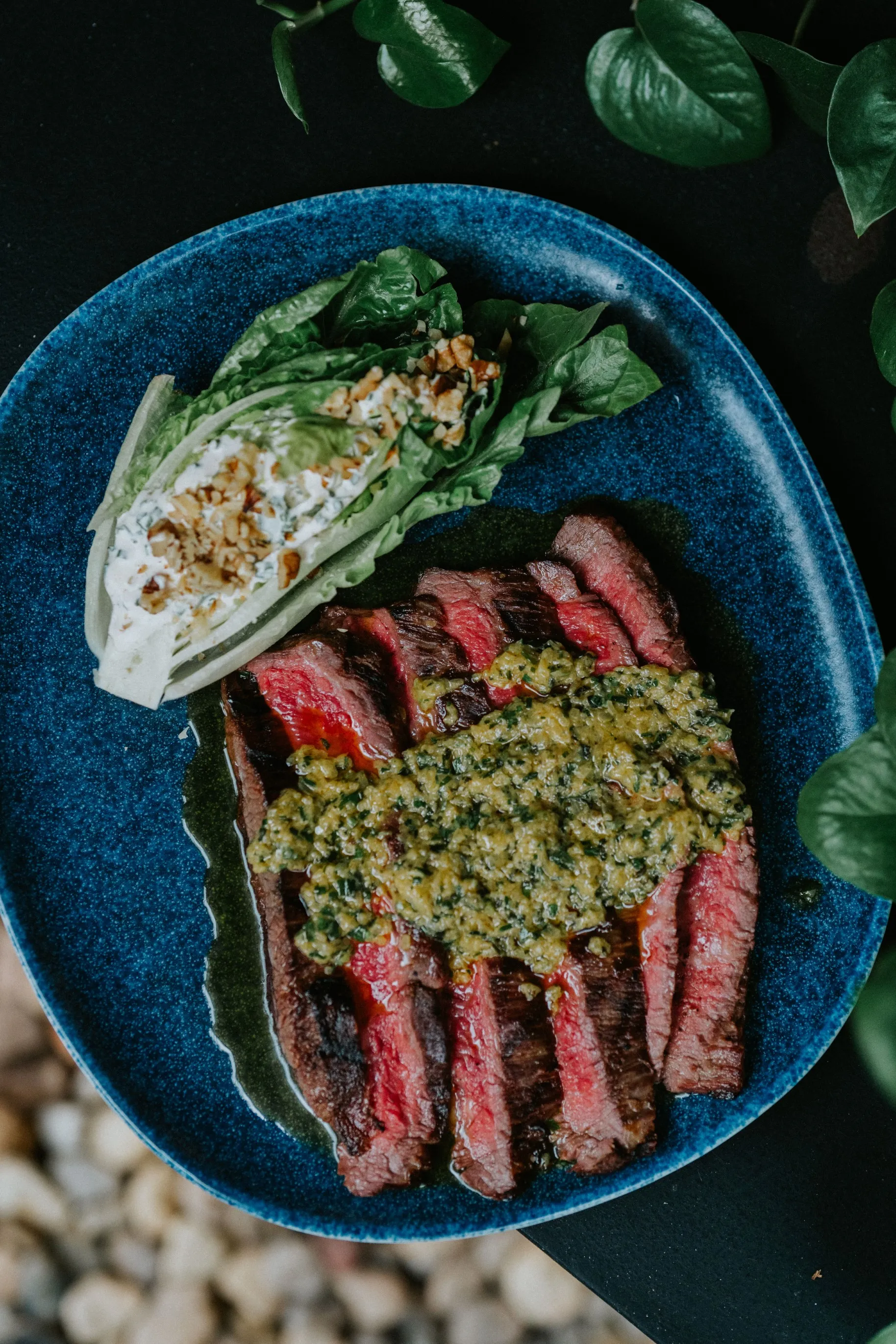 A steak topped with vibrant green sauce, adding a burst of flavor and visual appeal to the dish.