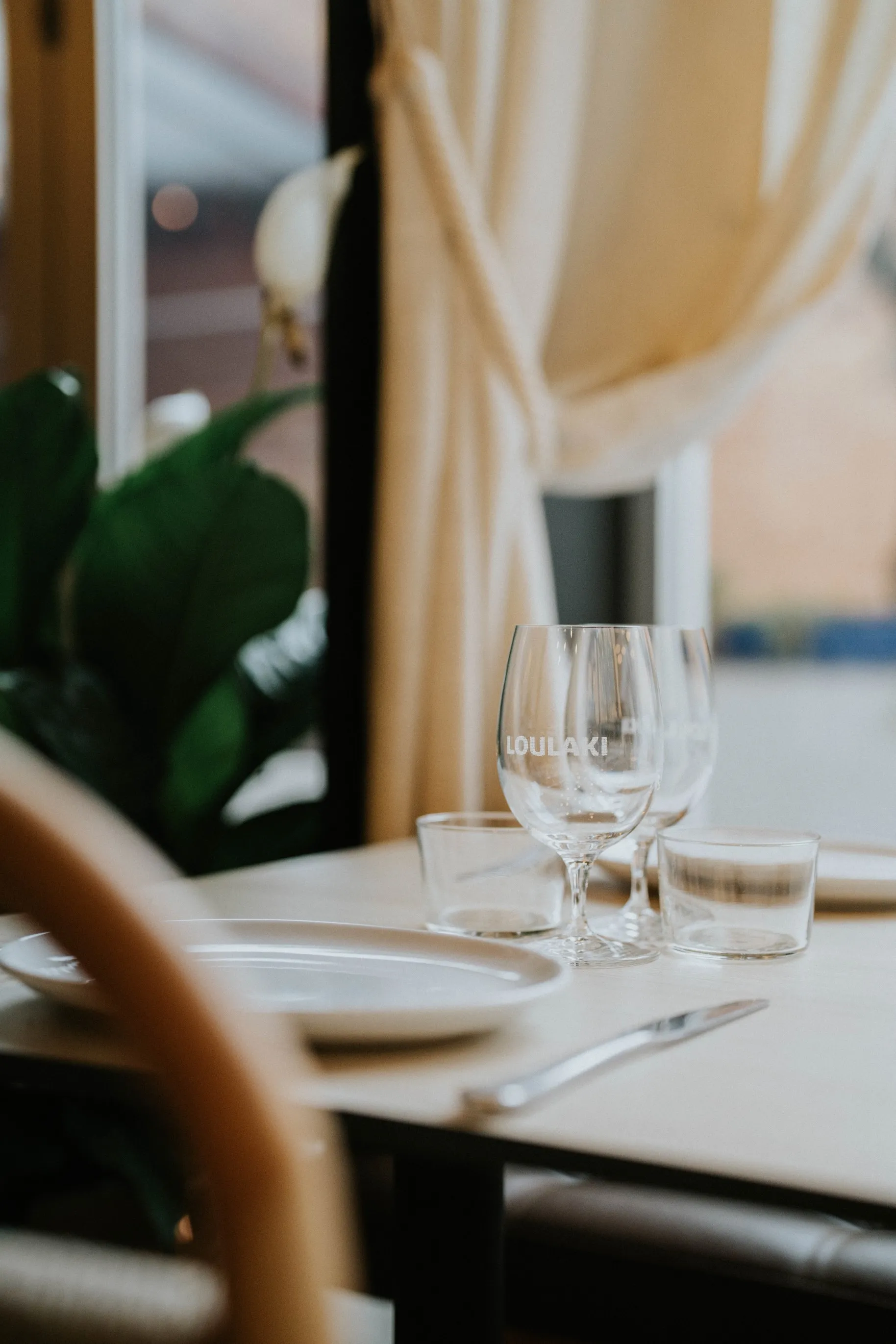 Table with empty glasses and a plant on top, creating a simple yet elegant centerpiece.