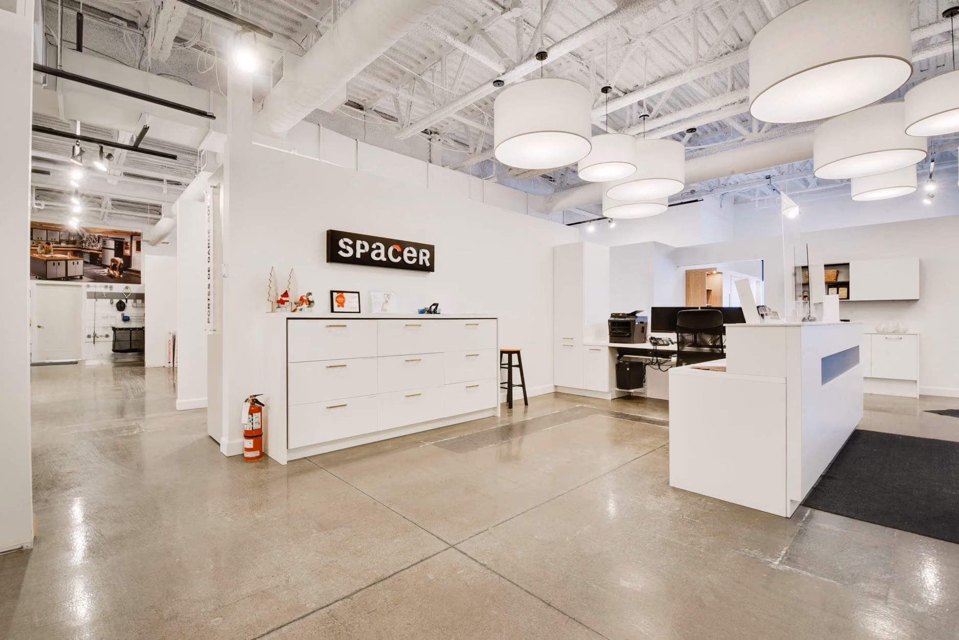 Aménagement commercial Le Spacer avec comptoir d'accueil blanc, par Constromax