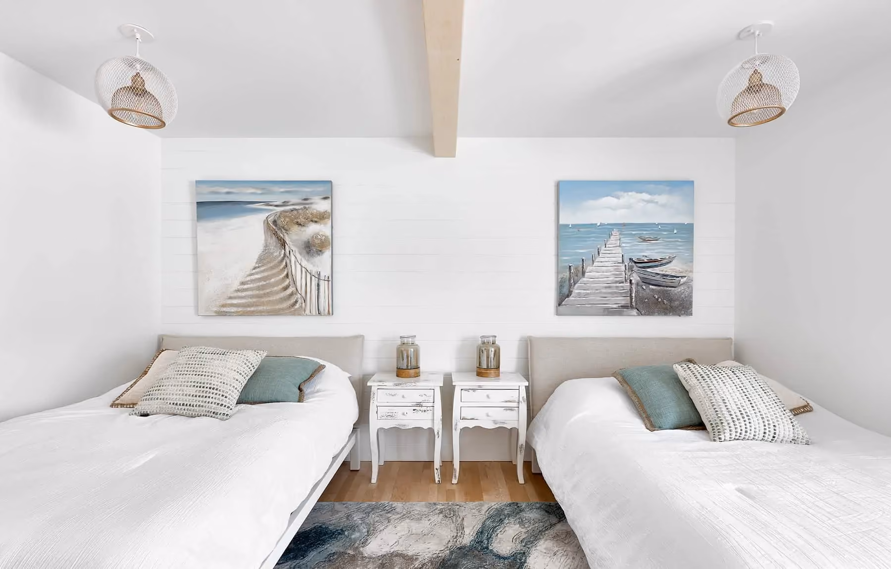 Chambre rénovée avec deux lits et poutres apparentes