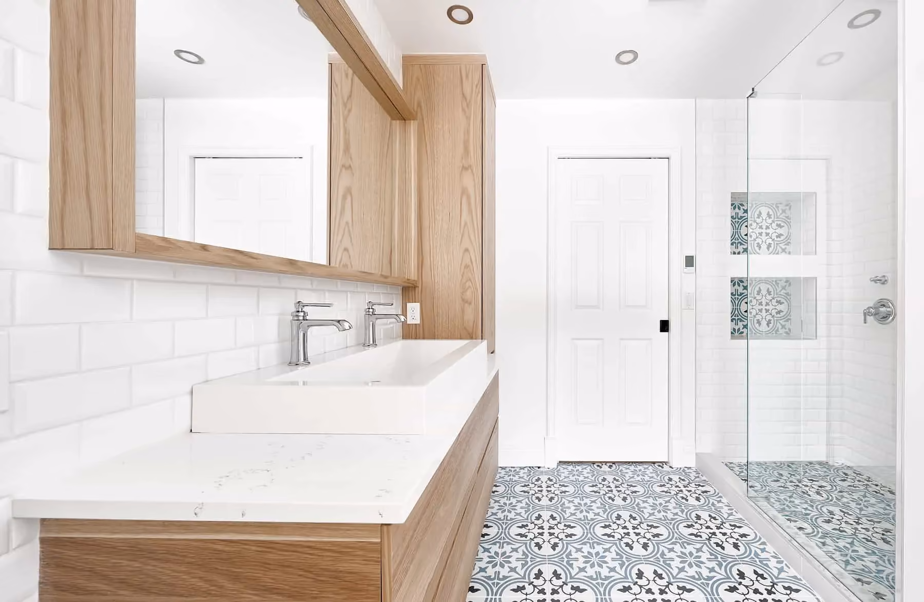 Salle de bain rénovée avec vanité en bois et plancher à motif