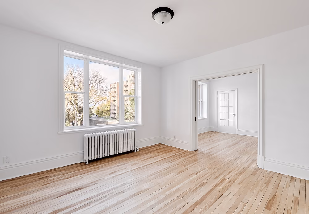 Chambre rénovée avec plancher de bois et fenêtres