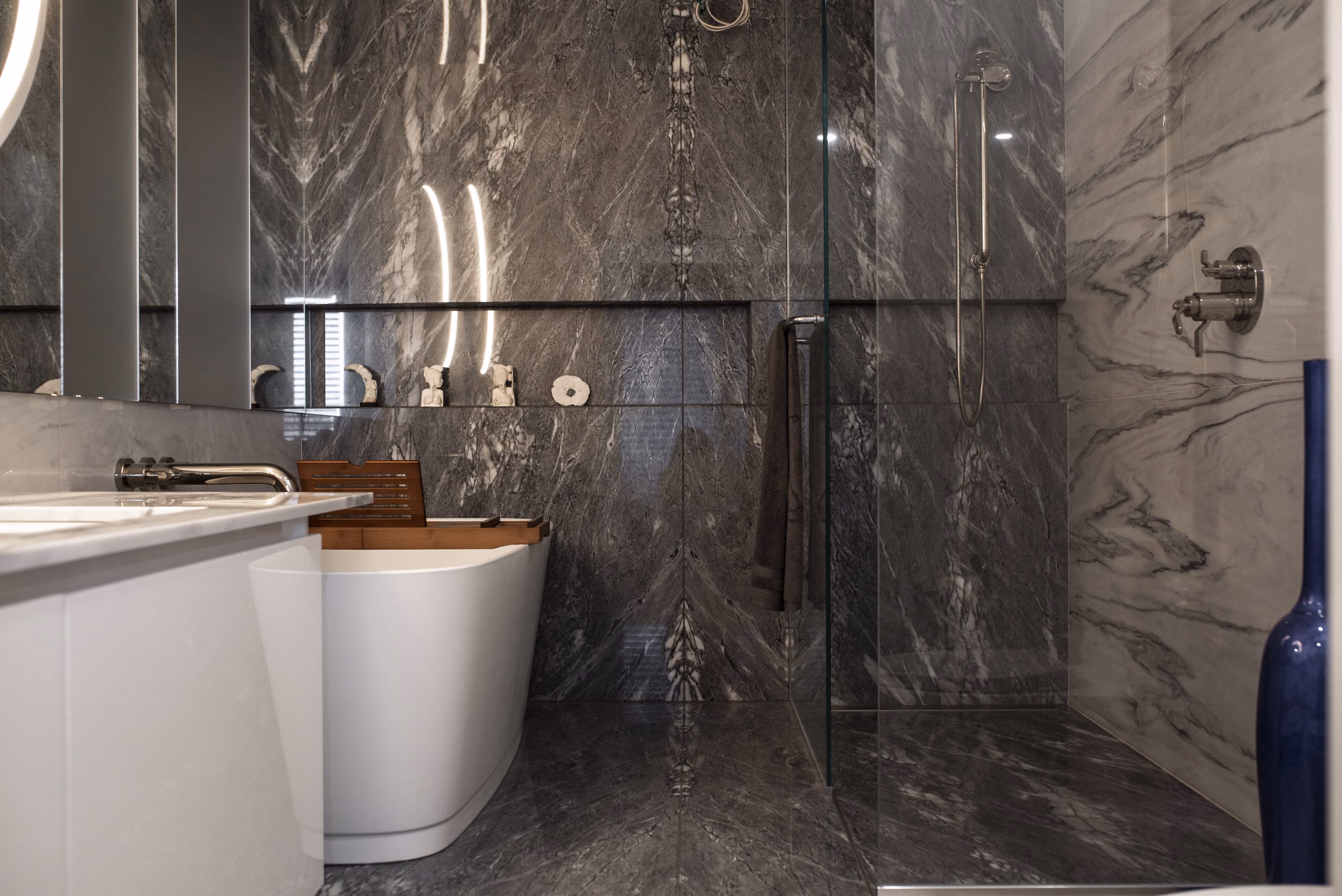Salle de bain de luxe rénovée avec bain autoportant et marbre foncé, projet George V par Constromax