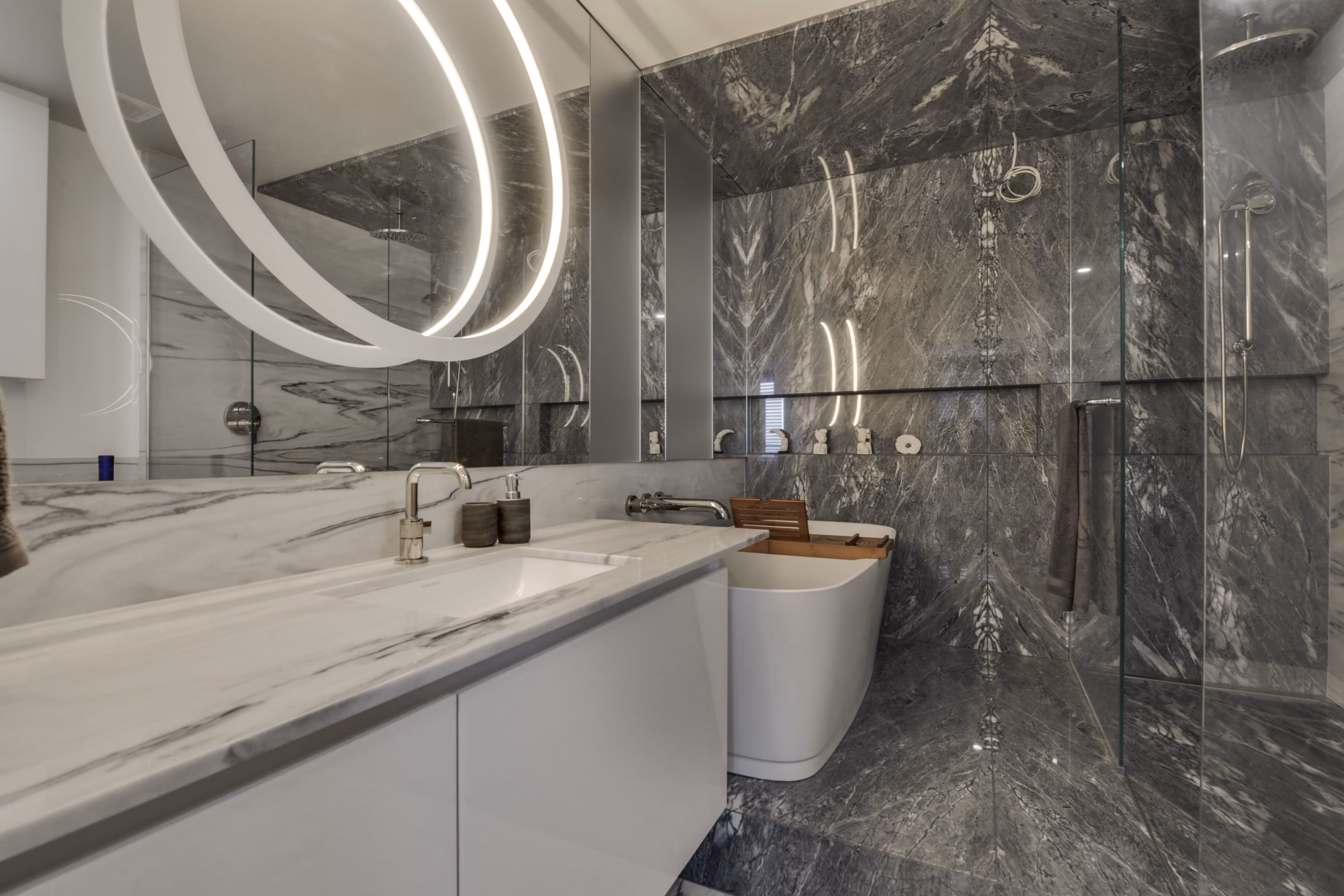 Salle de bain avec luminaire circulaire et murs de marbre