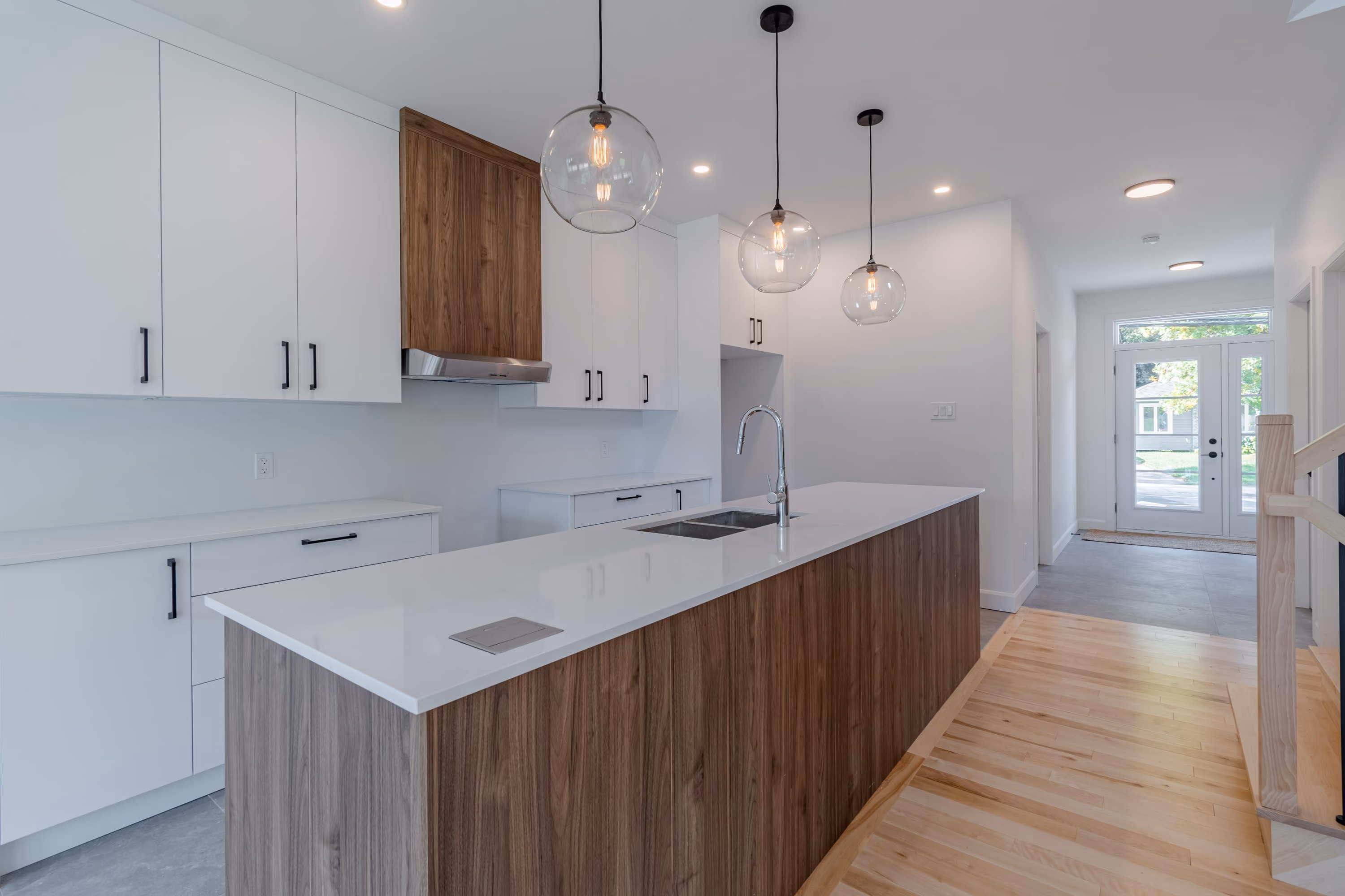 Cuisine blanche avec îlot en bois et luminaires suspendus du jumelé farmhouse