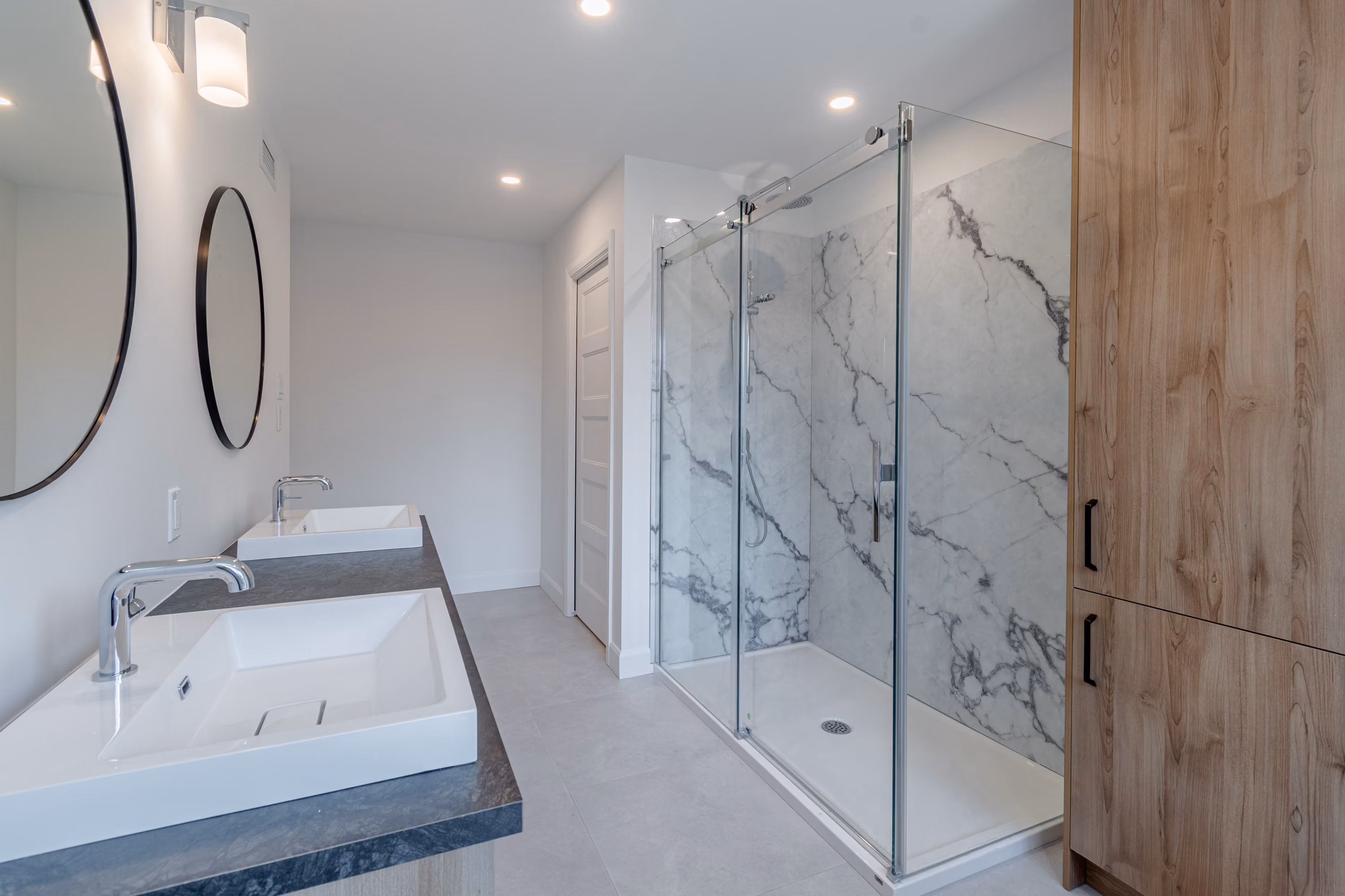 Salle de bain avec miroir rond et douche en céramique du jumelé farmhouse