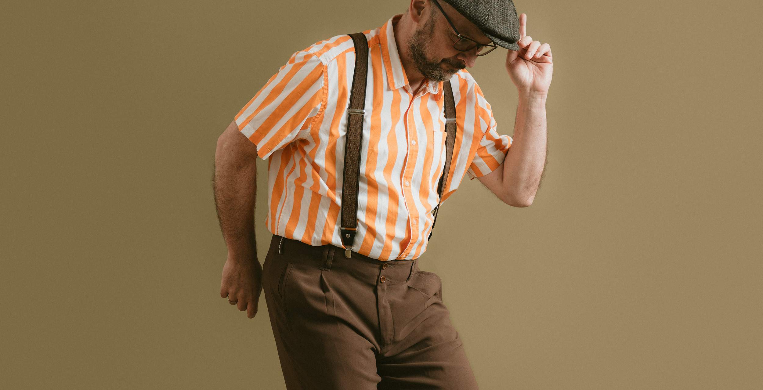 Tänzer mit Kappe und gestreiftem Hemd tanzt Swing