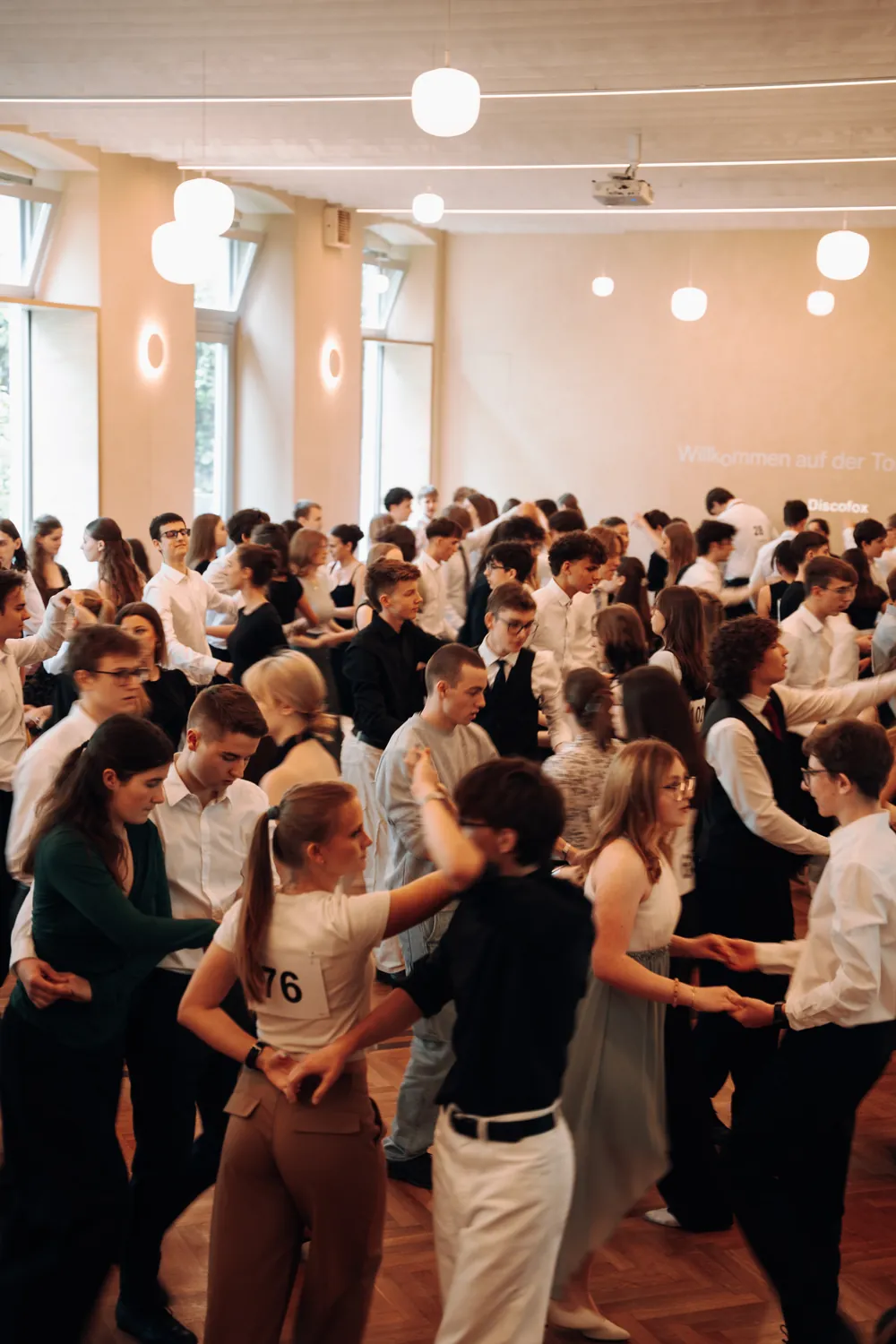 Jugendliche tanzen Discofox im vollen Tanzsaal der Tanzschule Horn