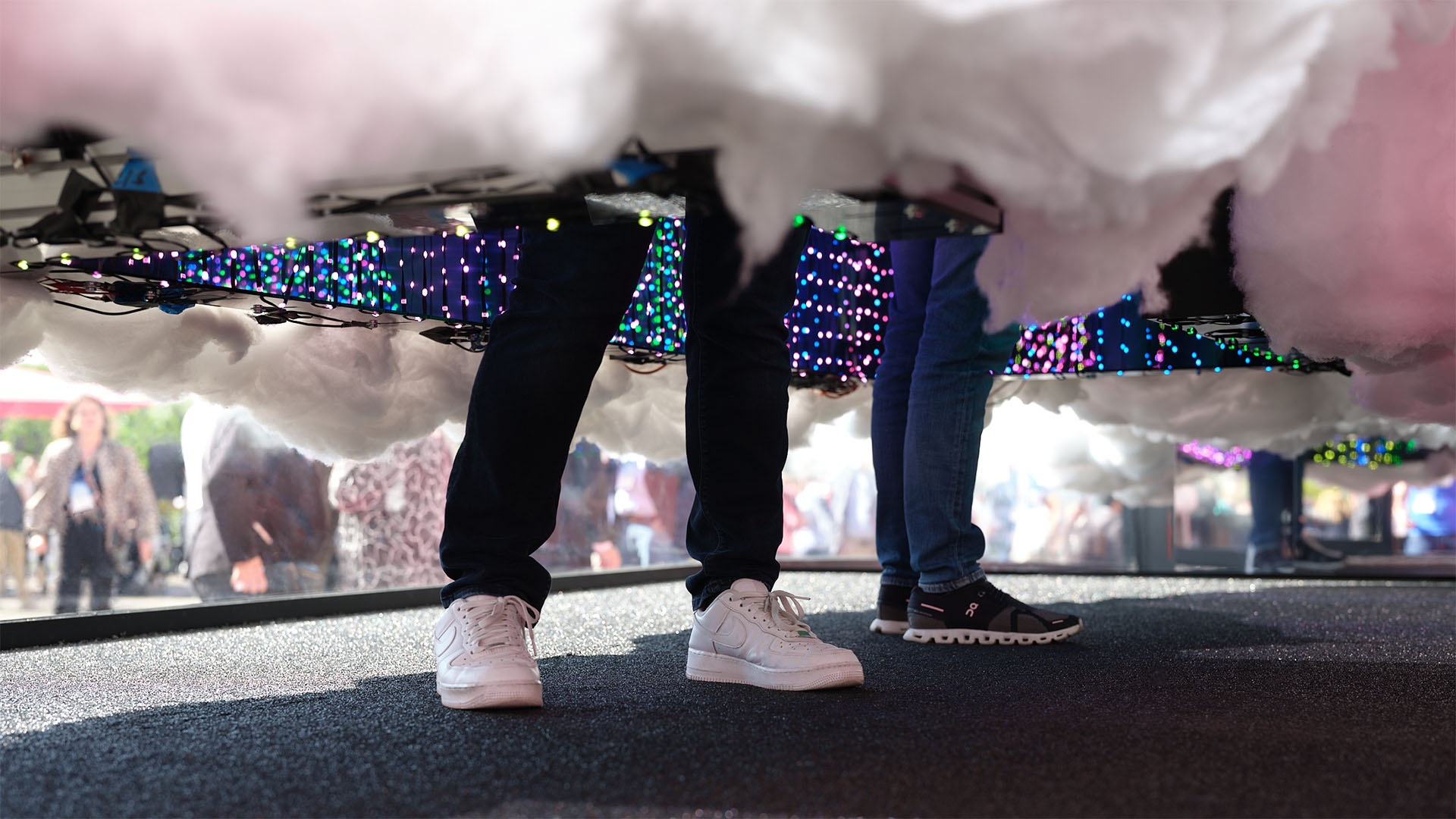 Besuchende stecken den Kopf in eine Öffnung der T Cloud und erleben die Wolke als multisensorischen Licht- und Klangraum.