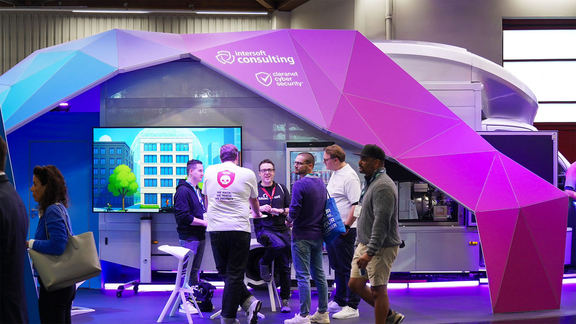 Blick in den Messestand von intersoft consulting mit eingerichteten Beratungsinseln, Sitzgelegenheiten und integrierten Technikstationen.