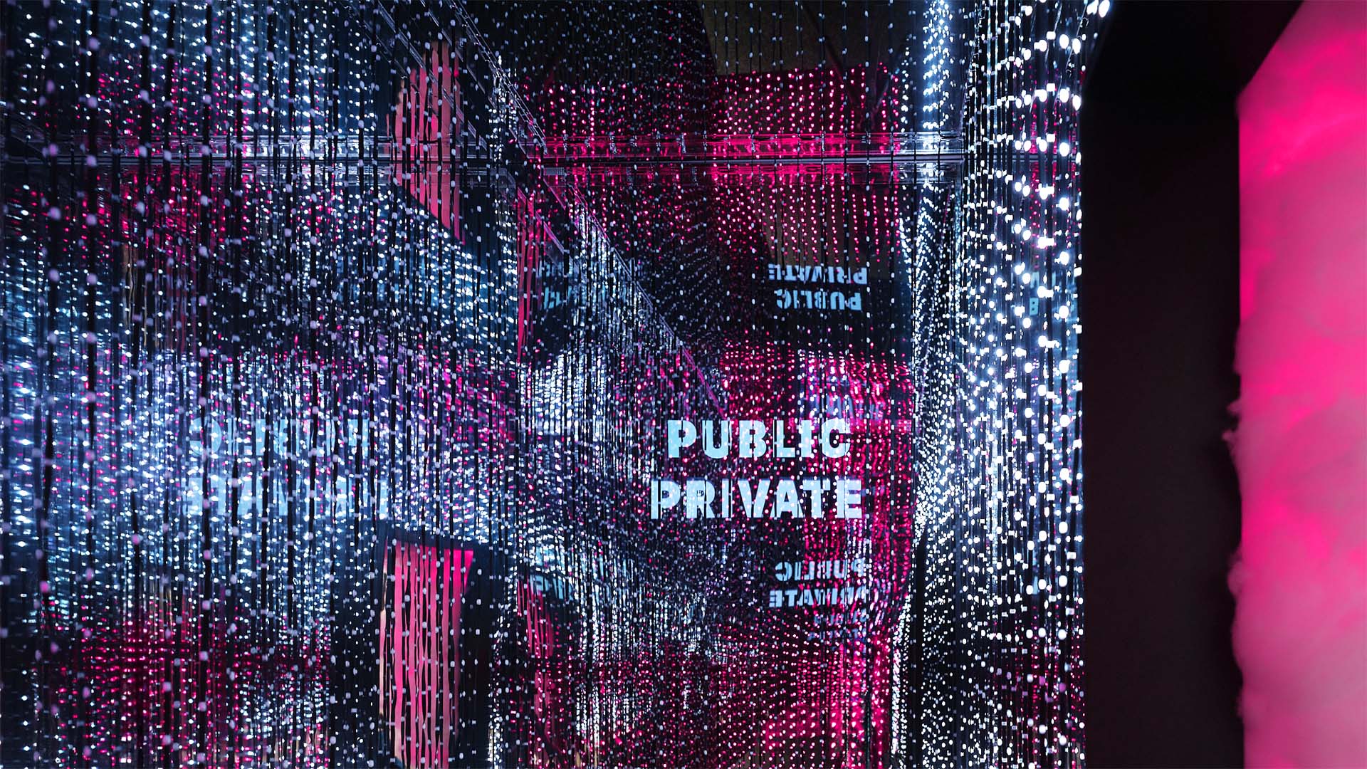 Innenansicht der T Cloud von T‑Systems mit immersiver Lichtbespielung, Spiegeloberflächen und reflektierten Besuchenden.