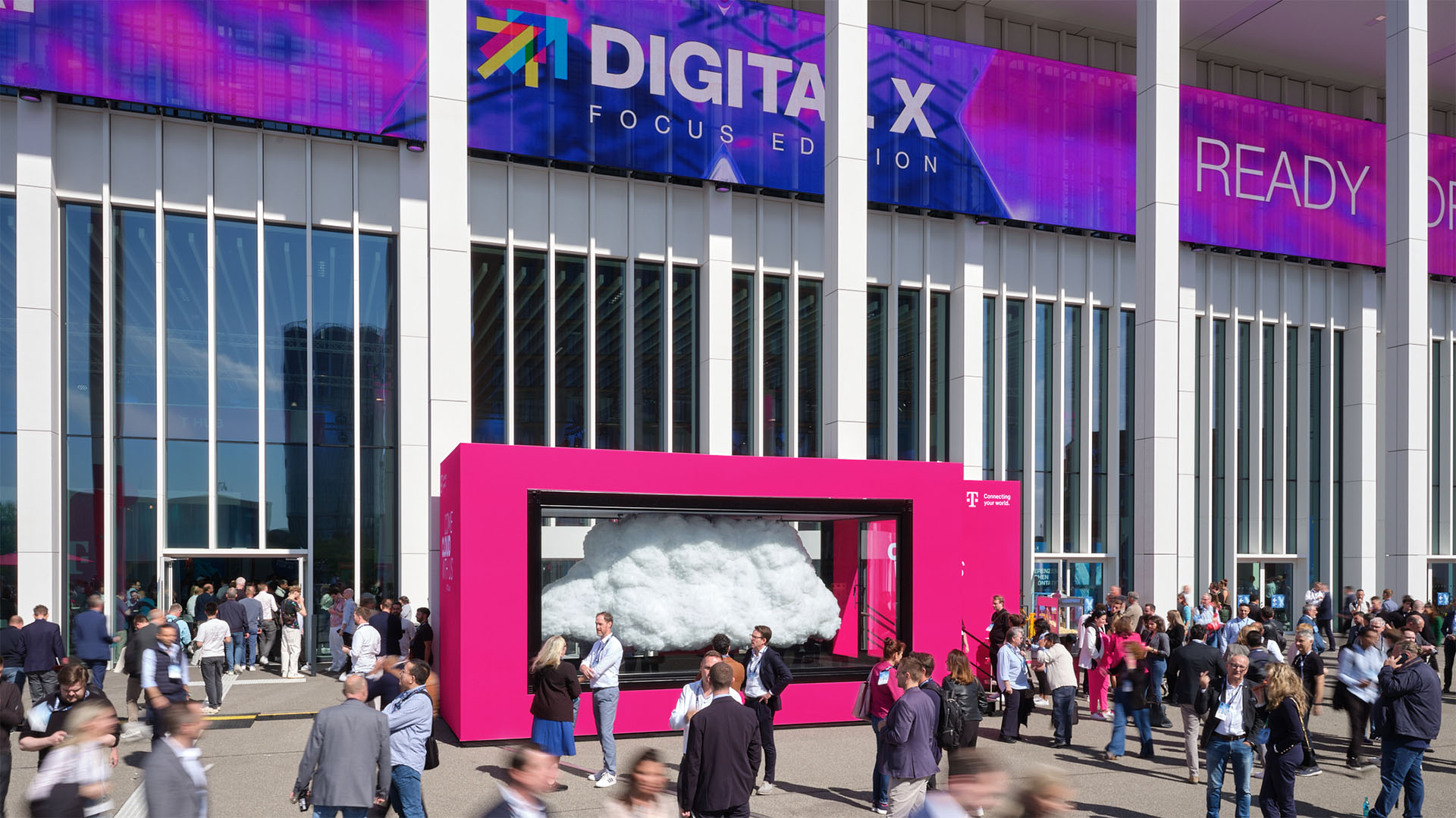 Blick über die Plaza der Digital X 2025 mit der T Cloud von T‑Systems als leuchtendem Publikumsmagnet.