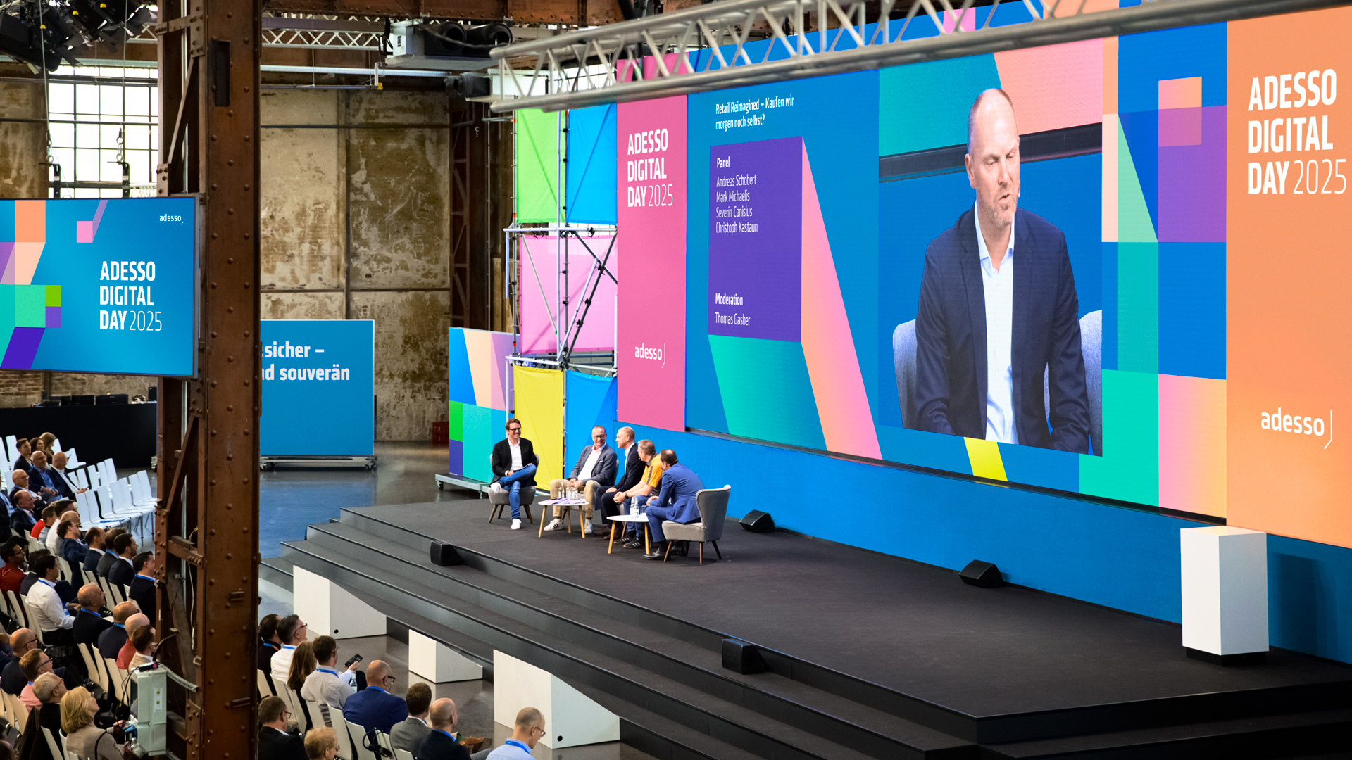 Expertenpanel auf der MainStage des Adesso Digital Day 2025: Diskussion zu „Retail Reimagined" vor LED-Bühnenwand im Eventdesign von Phocus Brand Contact.