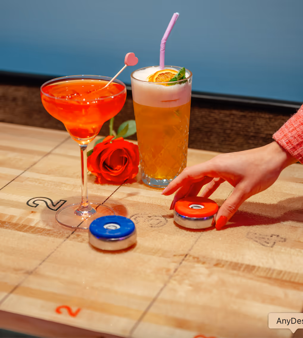 a shuffleboard table with cocktails and pucks on it.