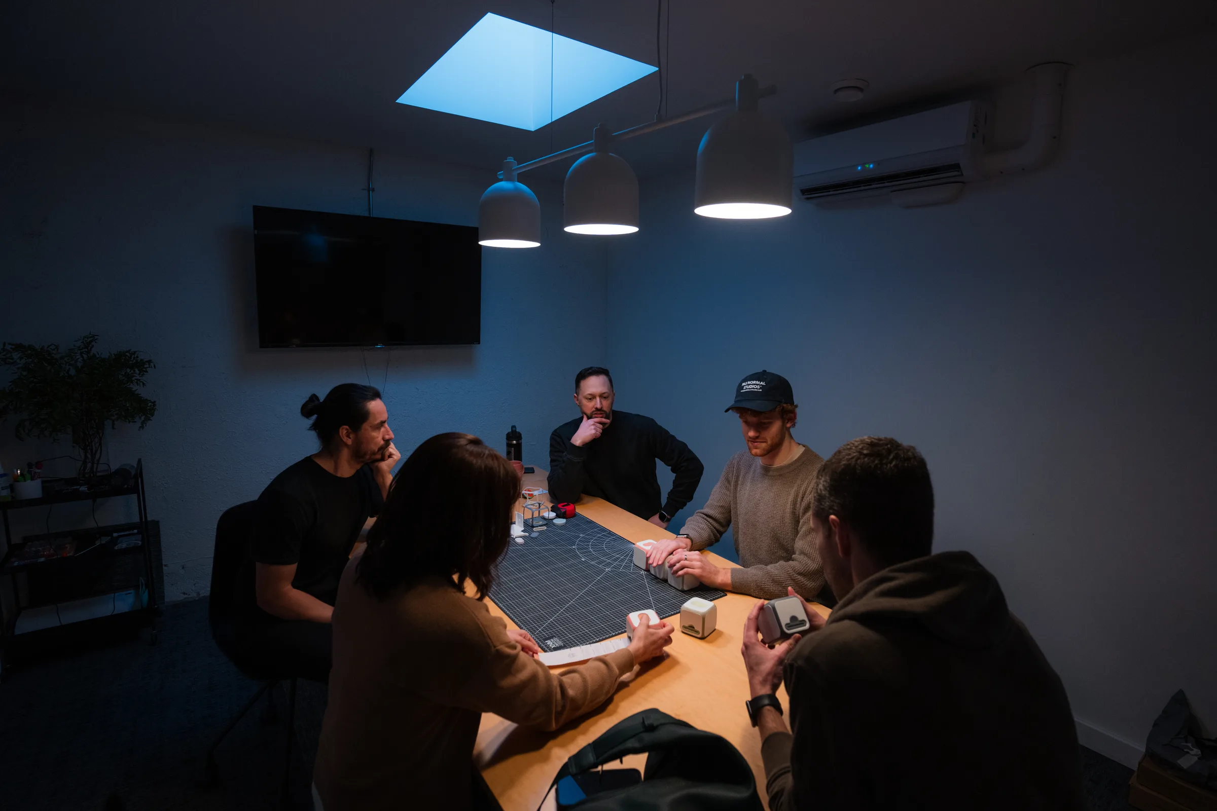 The ANCORD team reviewing prototypes around the worktable in the studio.