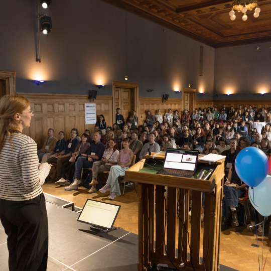 A picture of two smiling women in the audience raising their hands.