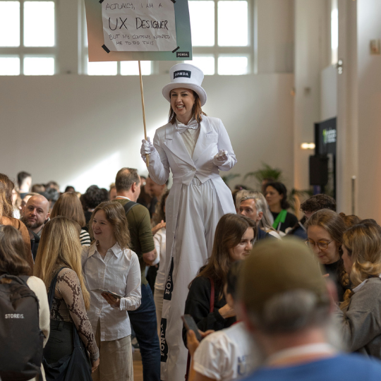 A picture of two smiling women in the audience raising their hands.