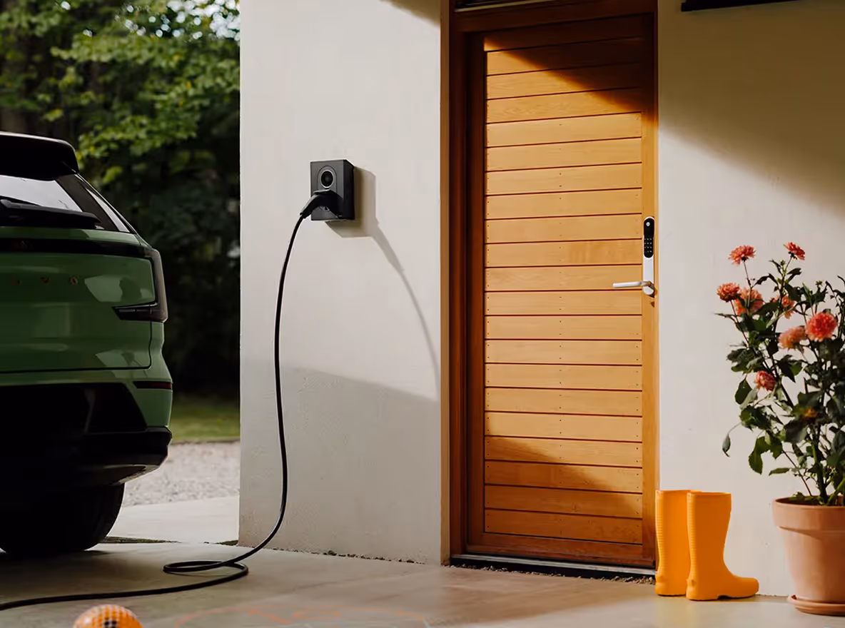 Elektrische auto wordt thuis opgeladen via een wandlader naast de voordeur.
