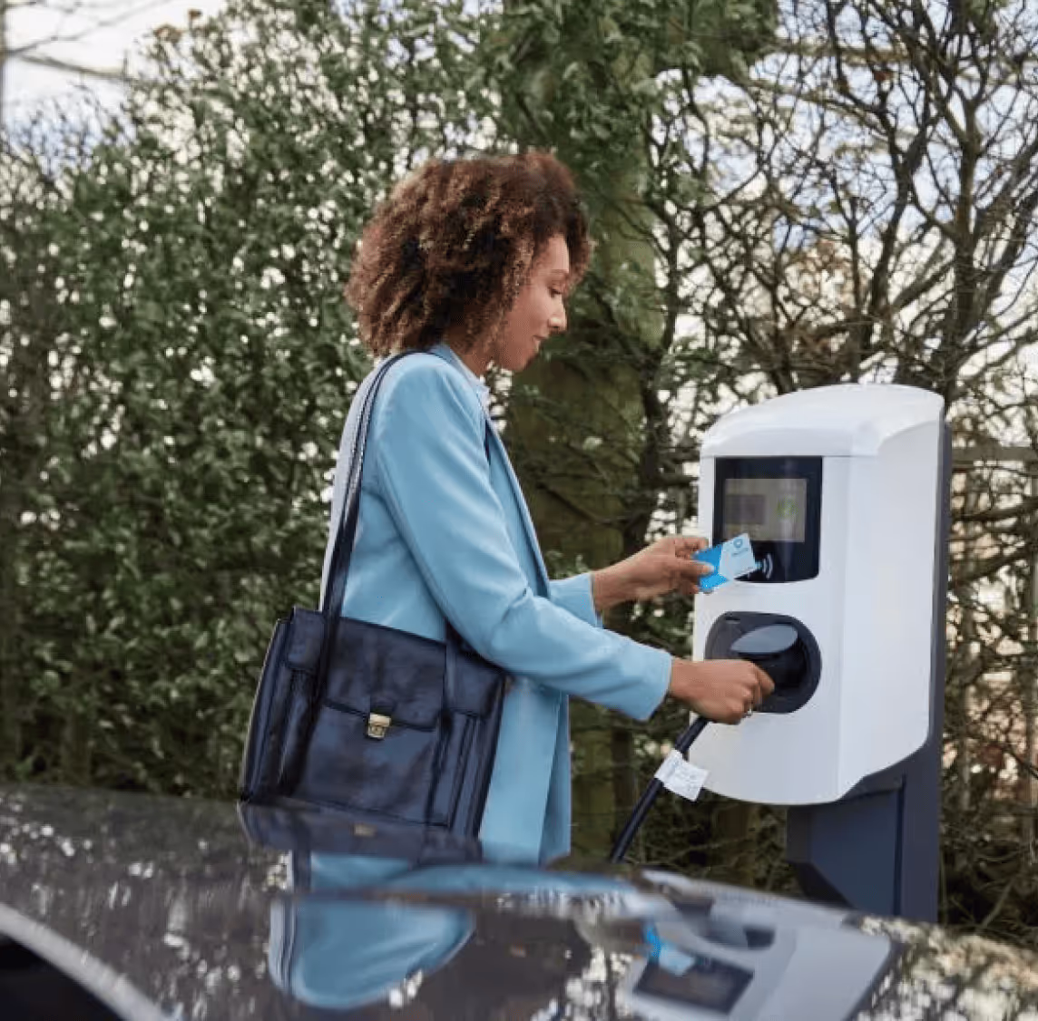 Vrouw die haar auto aansluit aan een snelle laadpaal.