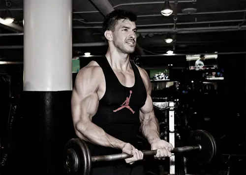 Body builder doing a bicep curl in chelsea new york city at completebody.