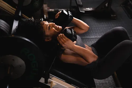 Woman body builder on hack squat in chelsea new york city at completebody.