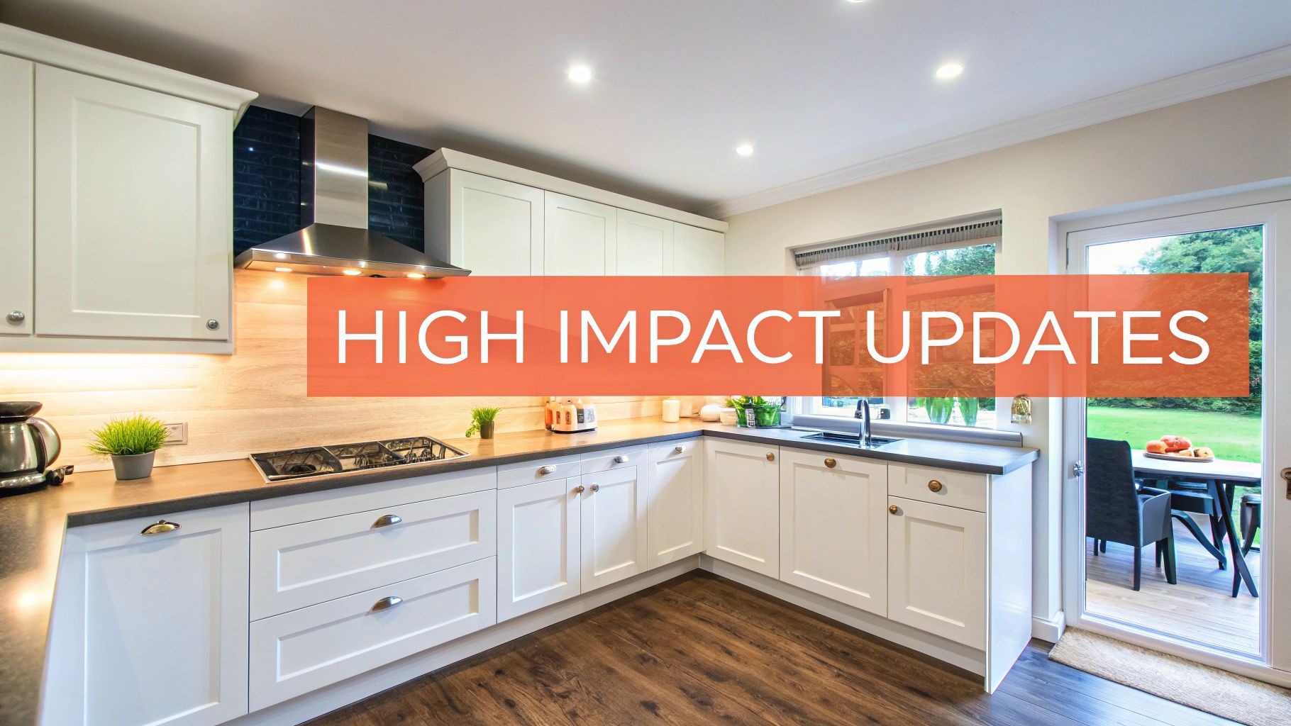 A bright, modern kitchen with white cabinets, dark countertops, wood floor, and a view to a patio.