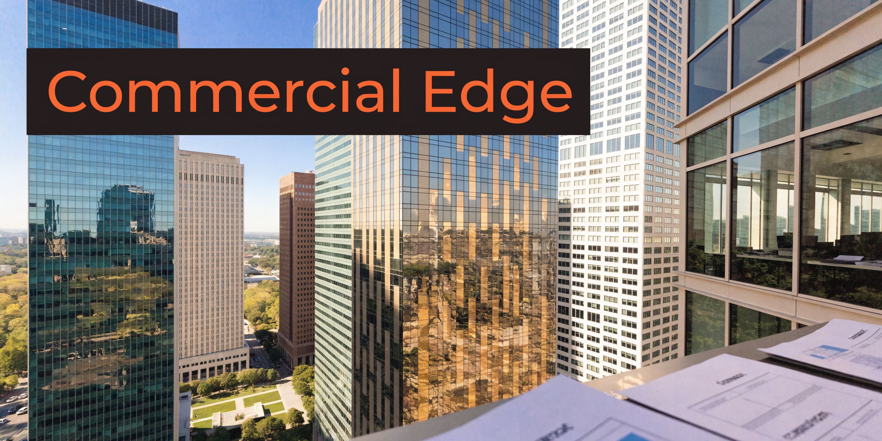 A view of modern glass skyscrapers in a bustling city from a professional high-rise office workspace.