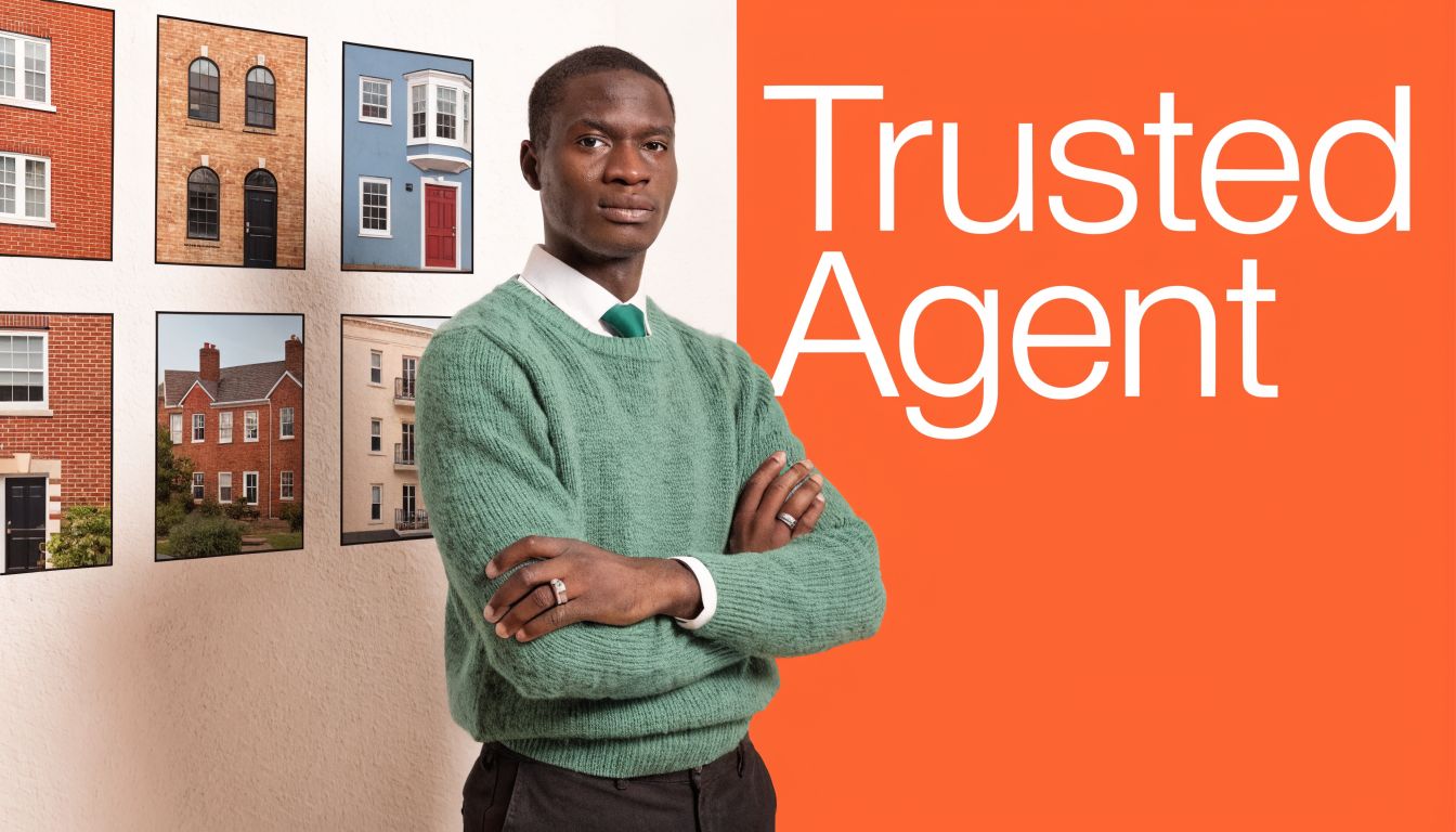 A professional real estate agent standing with arms crossed in front of a wall featuring house images.