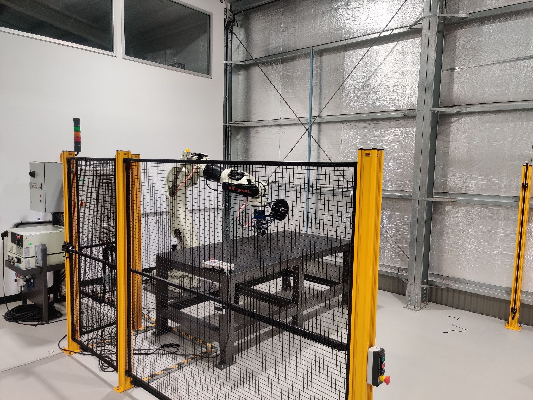 A complete AFP-XS cell installed on a Kawasaki 6-axis robot arm — production-ready thermoplastic fibre placement within a standard industrial footprint.