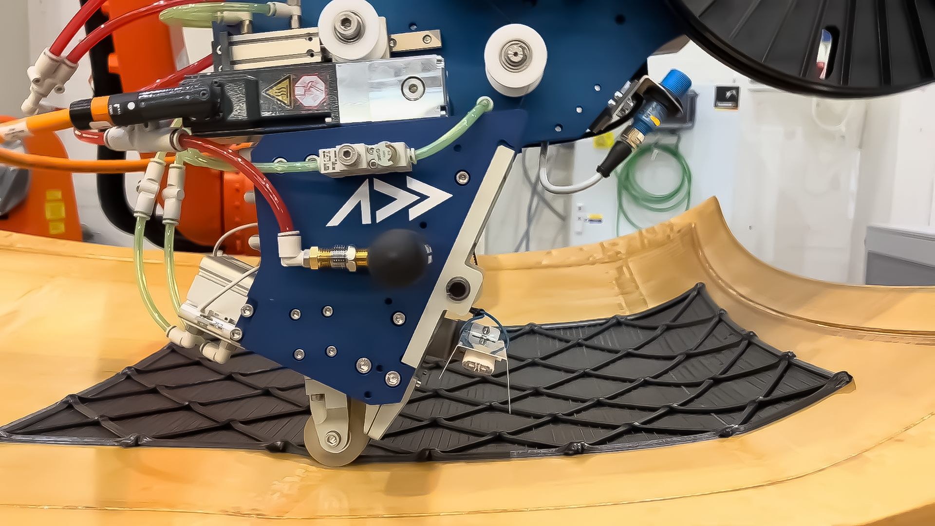 AFP-XS end-effector laying carbon fiber tow on automotive roof geometry mold