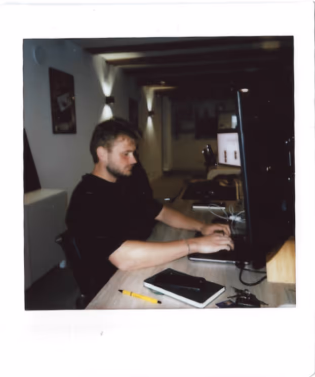 Man achter computer in een kantoorruimte.