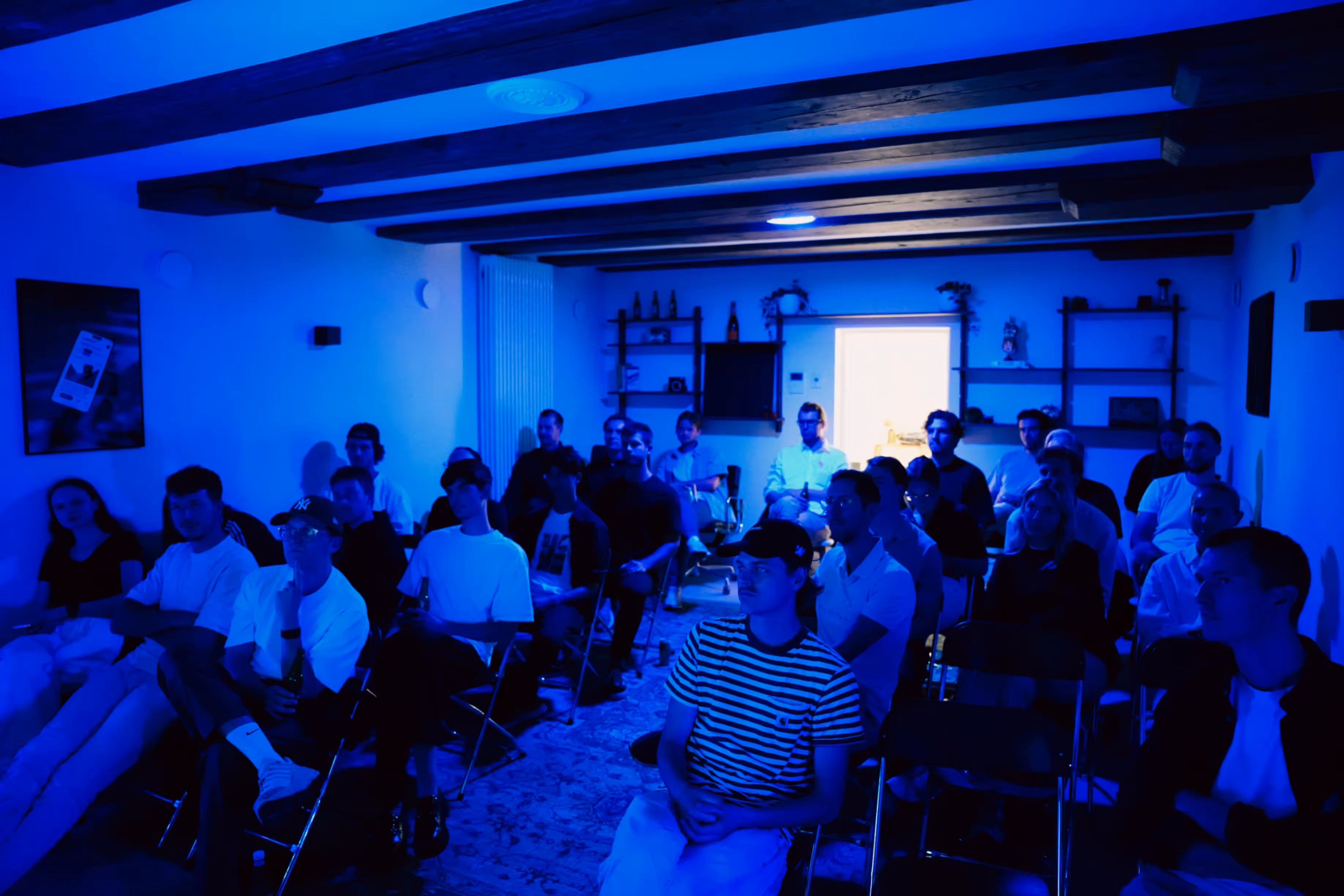 Mensen in een zaal met blauwe belichting.
