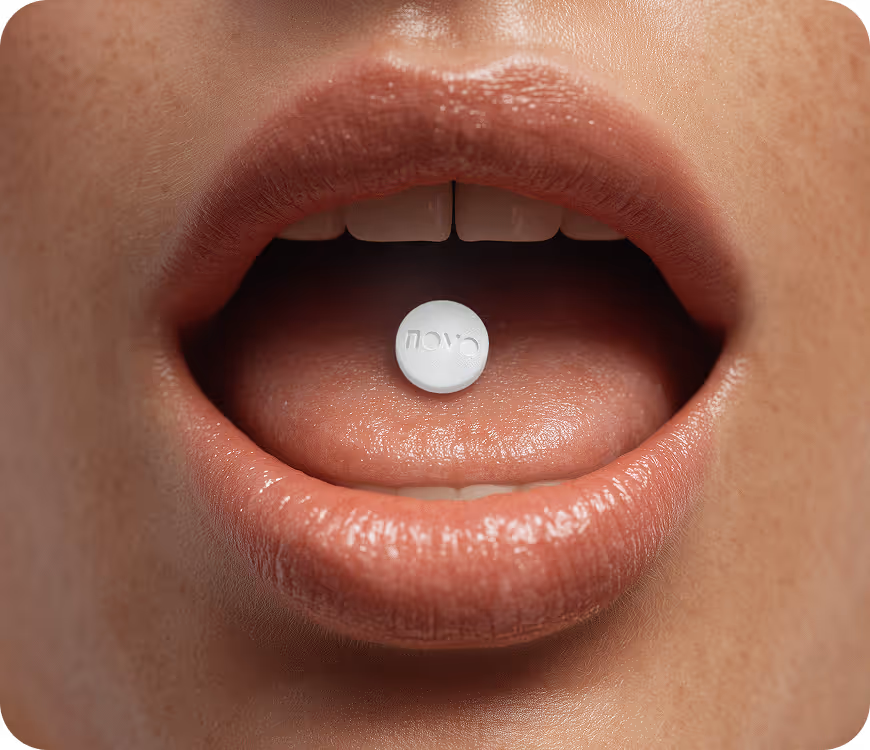 Close-up of a person's open mouth with a white pill labeled 'novo' resting on their tongue.