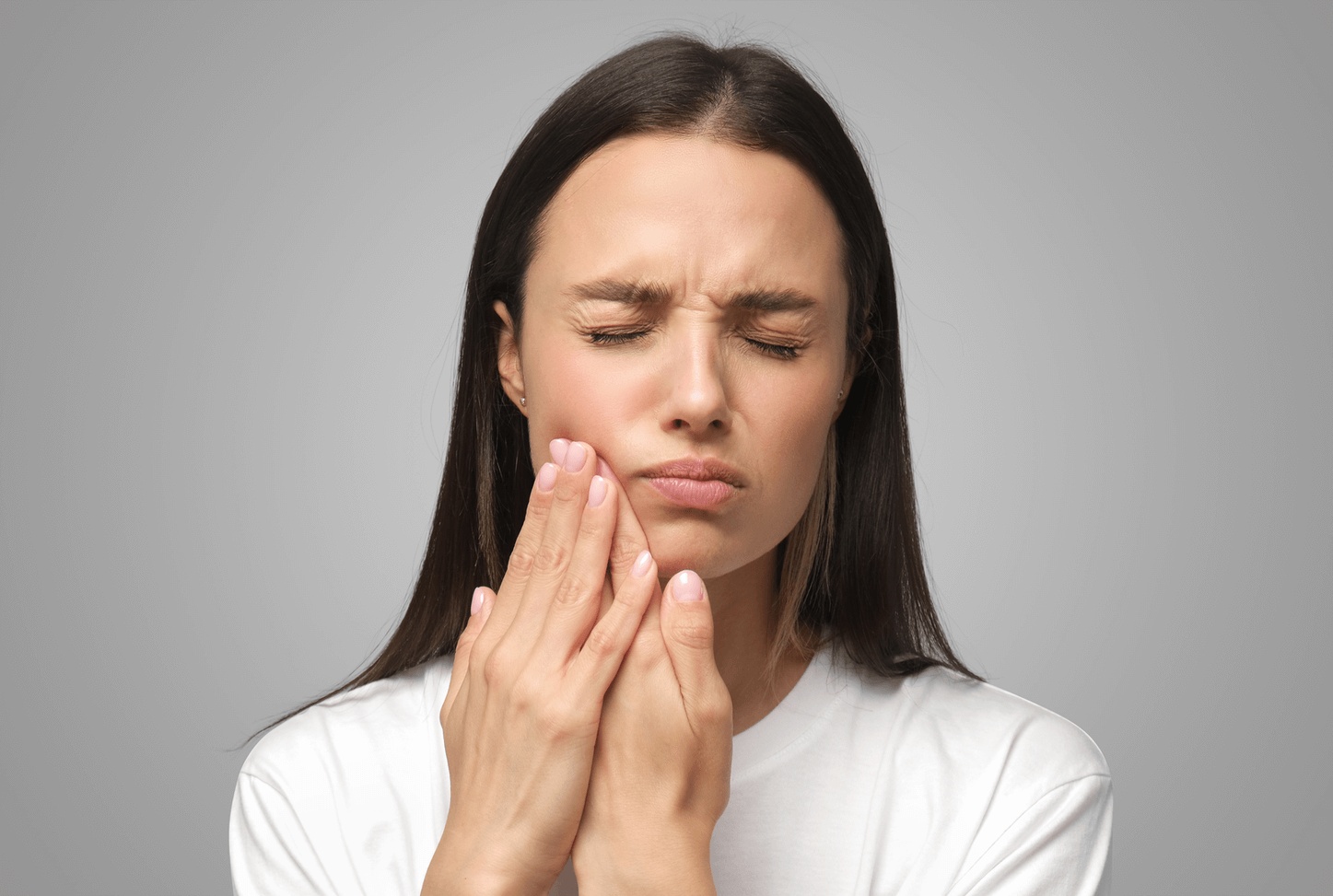 Woman experiencing a painful toothache and jaw discomfort, seeking urgent care from the best dentist for dental emergency in Naperville.