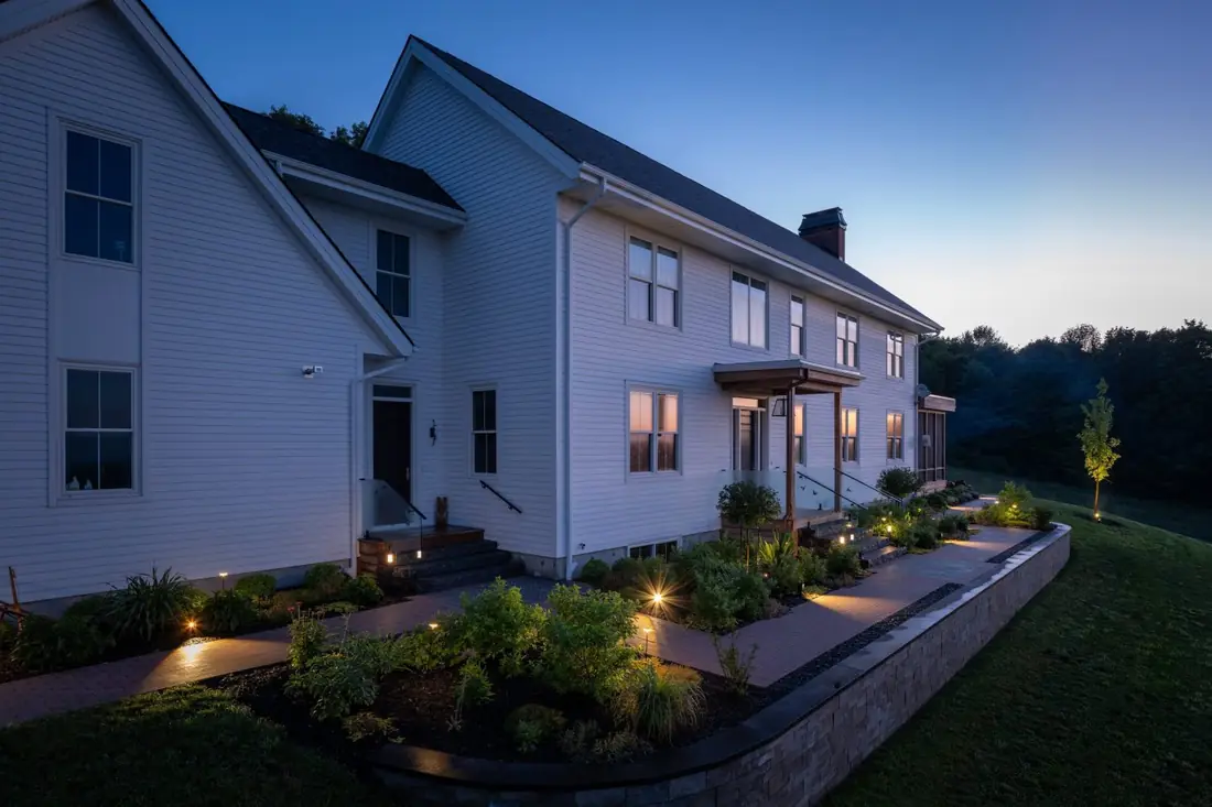 Farmhouse gardens and landscape lighting at dusk