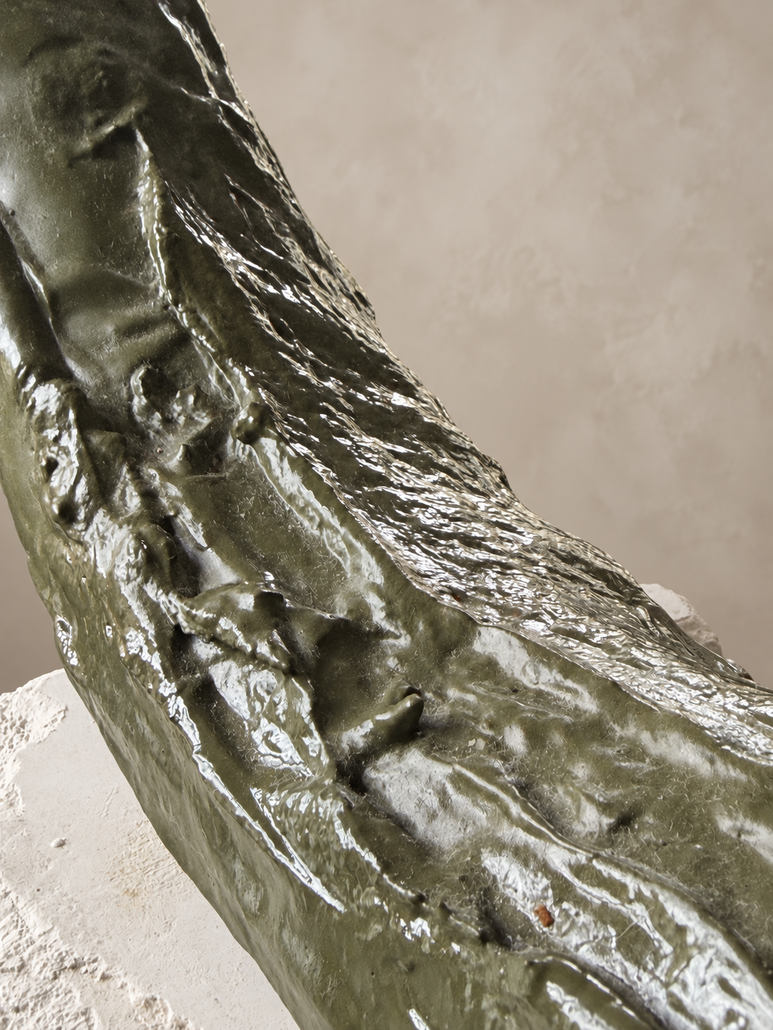 Close view of the hand-worked olive-green surface of Continuum
