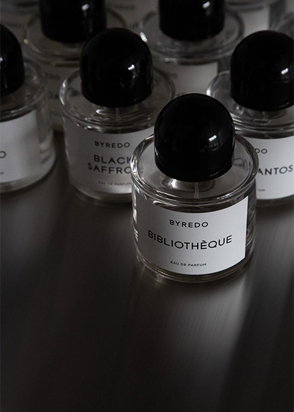 Byredo perfume bottles with “Bibliothèque” in focus and other fragrances blurred in the background.