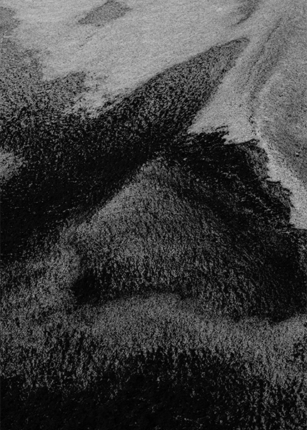 Abstract black and white photograph of textured patterns in Iceland’s volcanic black sand.