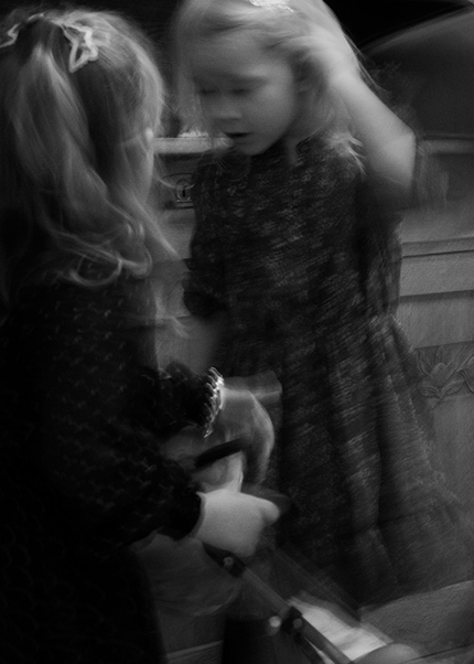 Black and white photo of a child reflected in a mirror with blurred motion, creating a dreamlike effect.