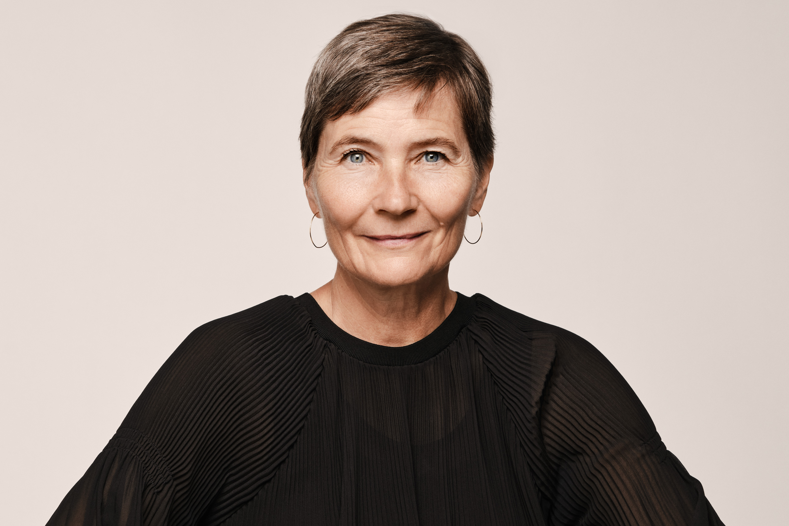 A professional studio portrait of Lene Dammand Lund, Rector of the Royal Danish Academy, wearing a black blouse against a neutral background.