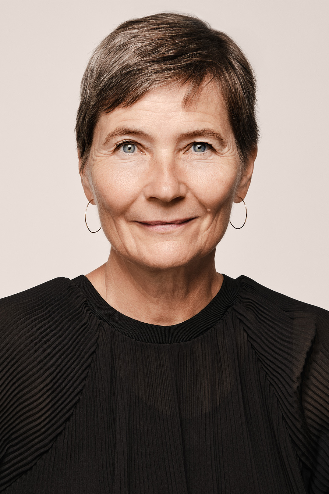 A professional studio portrait of Lene Dammand Lund, Rector of the Royal Danish Academy, wearing a black blouse against a neutral background.