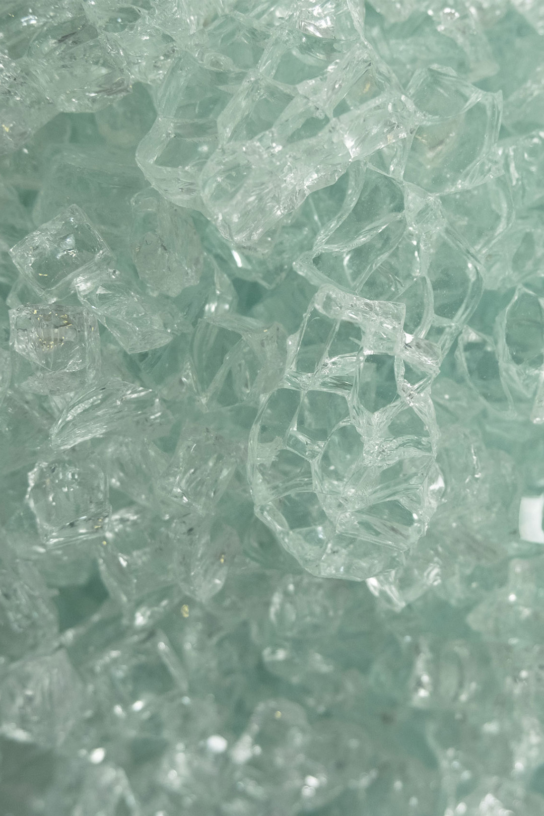 Abstract macro photograph of translucent glass fragments captured by Jana Katrín and Patrick Pankalla, showcasing texture, light, and organic form for Dream Makers project.