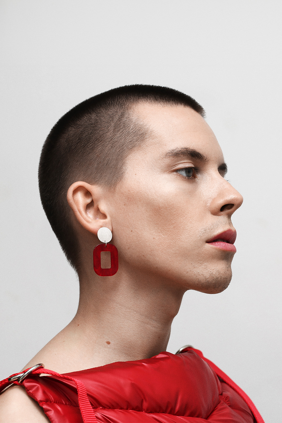 Fashion portrait of Emil Ljungberg for PERSUEDE Copenhagen campaign photographed by Patrick Pankalla, featuring a minimalist red look and modern jewelry styling.