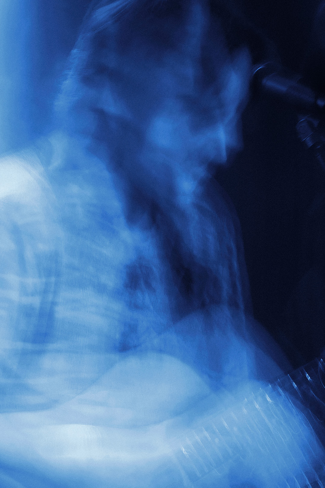 Ethereal close-up of a musician's hands on a guitar, emphasizing the fast-paced motion of a live performance by Patrick Pankalla.