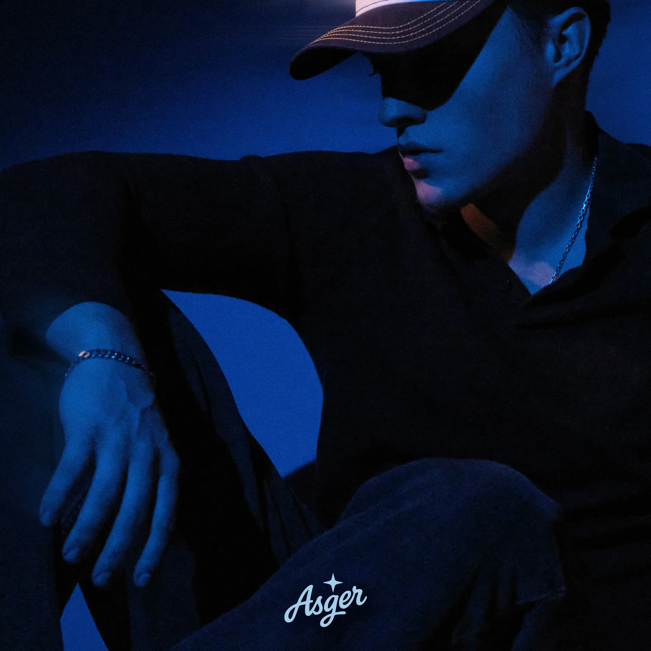 Official single cover art for Asger, featuring a moody blue studio portrait shot by Patrick Pankalla.