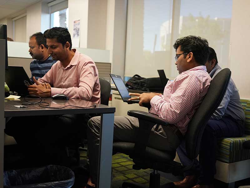 MGM digital ventures developers writing code on computers in their office.