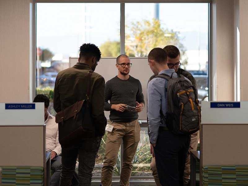 A group of MGM RESORTS digital ventures developers talking in the hallway.