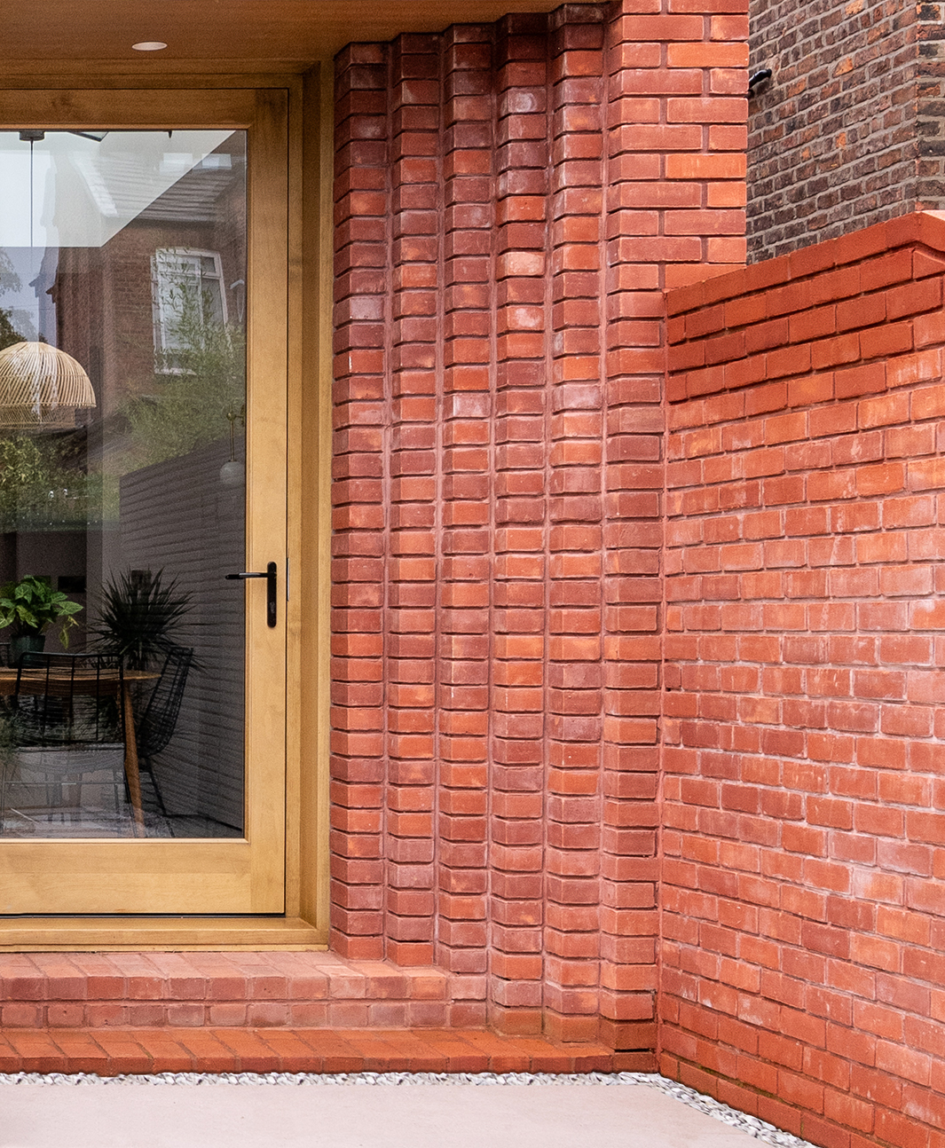 A red brick Victorian terraced house with a stepped brickwork in Chorlton, Manchester.