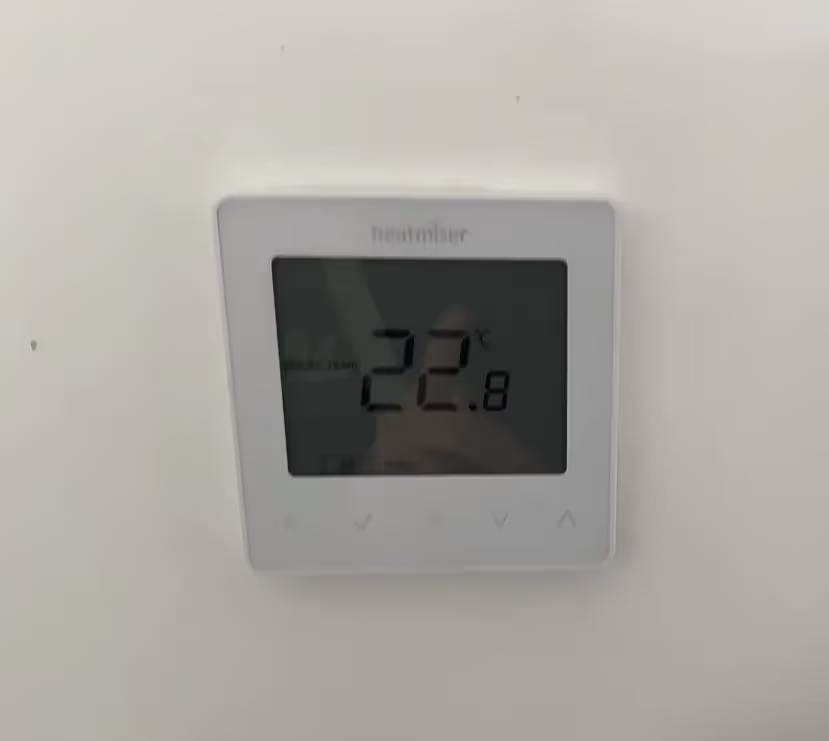 A thermostat on a plain wall