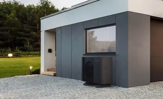 Image of a Samsung Quiet R32 Heat Pump outside a modern bungalow underneath a window